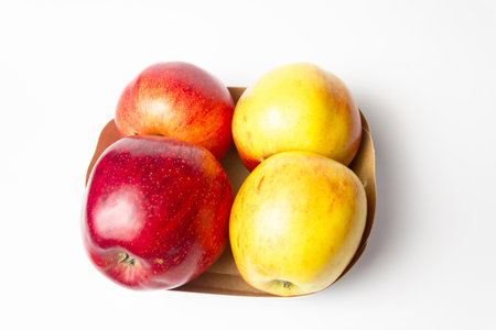 Red and yellow apples in a package on a white background