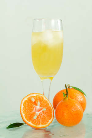 glass of champagne with cocktail, juice with ice tangerines with lmstochkami on glass light backgroundの写真素材