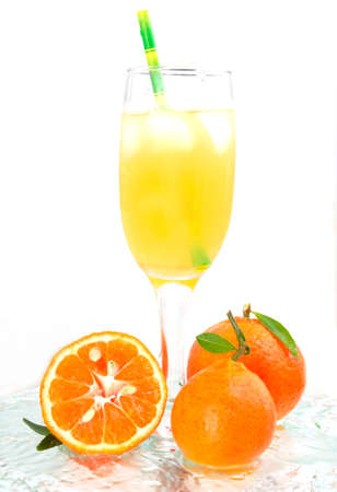 glass of champagne with cocktail, juice with ice tangerines with lmstochkami green tube on glass light backgroundの写真素材