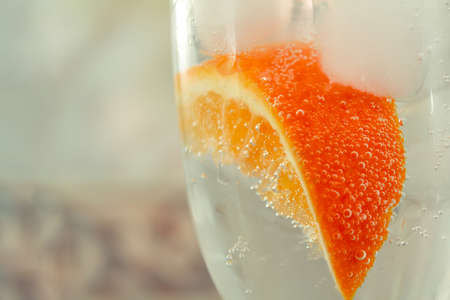 glass with oranges, ice, sparkling water close-upの写真素材
