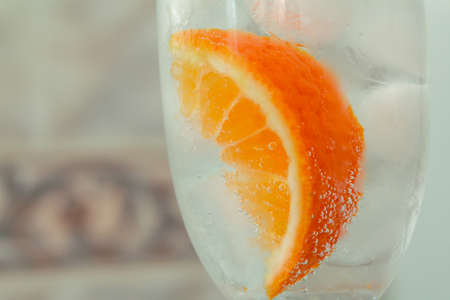 glass with oranges, ice, sparkling water close-upの写真素材