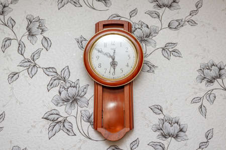 wooden vintage wall clock on a light wall