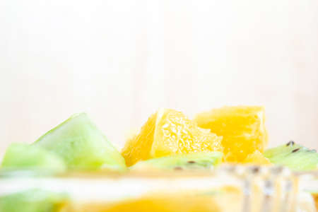 healthy breakfast salad of orange banana and kiwi in a glass dish on a wooden background fitness food. copy spaceの写真素材