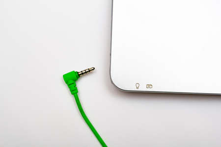 3.5 mm green jack and laptop on a white backgroundの写真素材