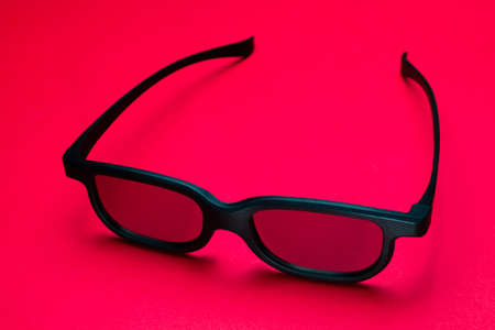 3D Glasses in a black frame on a red background. copy spaceの写真素材