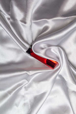 White silk fabric with bends and a red lighter. copy spaceの写真素材