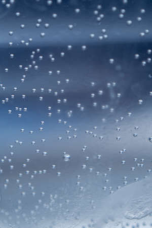 air bubbles in water on a blue background close-upの写真素材