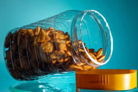 cookies in a jar in the form of a figure star triangle oval heart on teal background. close-up. copy...