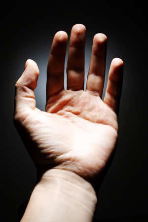 male hand on a dark background isolate. copy space close up