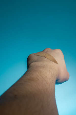 medical plaster on the hand wound, cut on a blue background
Â Â Â  copy space. close upの写真素材