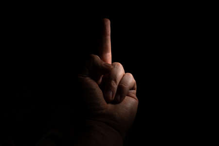male hand with outstretched middle finger fak on a black background copy space. close upの写真素材