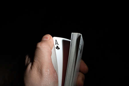 hand flips a deck of poker cards on a black background copy space. close upの写真素材