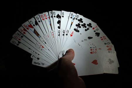 hand hold double fan from poker cards deck on black background copy space. close upの写真素材