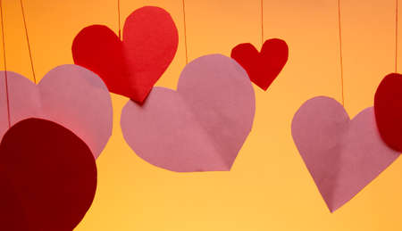 hearts red and pink on a string valentines day love on an orange background. close up copy spaceの写真素材