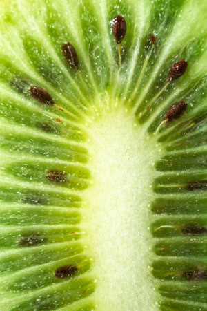 green kiwi with pits on a blue background. close upの写真素材