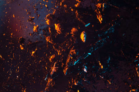 coals scatter in different directions with a blue-orange backlight on a dark background. close up copy spaceの写真素材