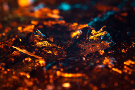 coals scatter in different directions with a blue-orange backlight on a dark background. close up copy spaceの写真素材