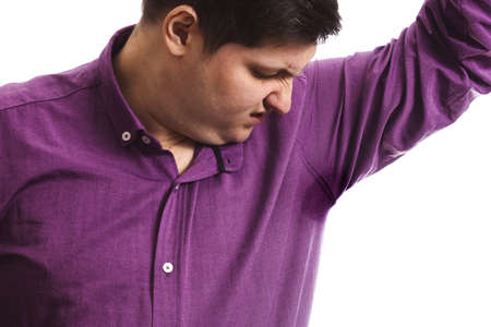 fat man in purple shirt with wet armpits stinks crooked face on a white background copy space isolateの写真素材