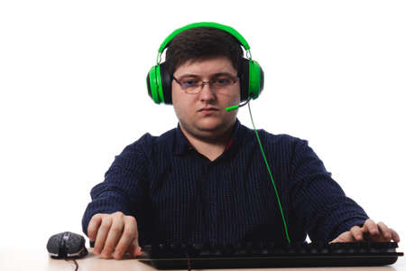 Young guy in a dark blue shirt green headphones gamer in glasses for vision on a white background. isolate. copy space