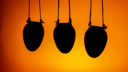 silhouette of three hanging flower pots decorative element of the house on an orange background copy spaceの写真素材