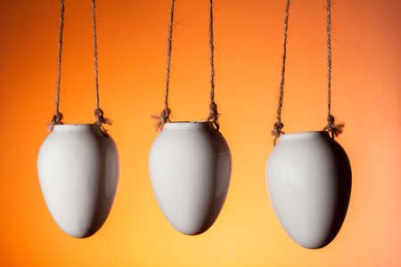 three hanging flower pots decorative element of the house on an orange background copy spaceの写真素材