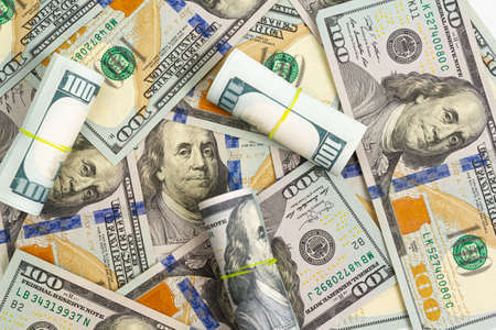 Pattern of one hundred dollar bills and rolls on a white backgroundの写真素材