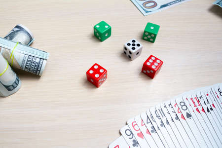 money dollars dice playing cards gambling on a light wooden table