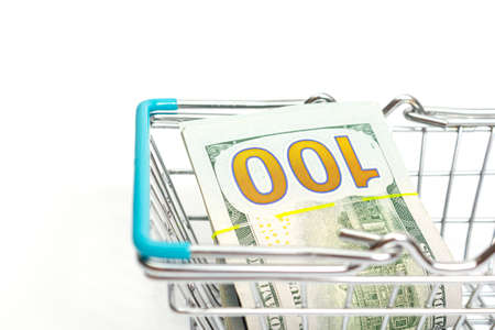 a basket with blue inserts is inserted into a bundle of hundred-dollar bills lies on a white background. isolateの写真素材