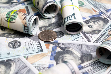 hundred dollar bills and rolls of notes and a quarter coin. side view. to closeの写真素材