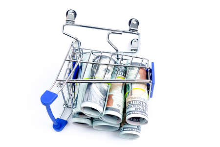 fallen shopping cart with rolls of one hundred dollar bills on a white background, isolateの写真素材