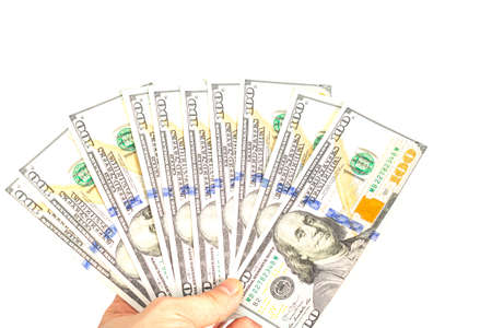 hand holds out a bundle of hundred dollar bills on a white background. isolate. close up