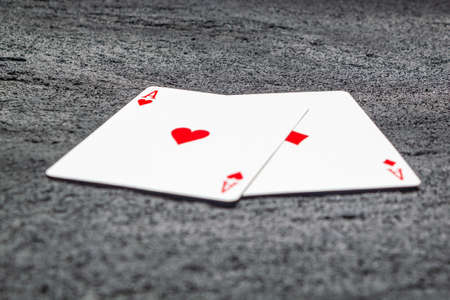 two red aces heart and diamond on black concrete dark background .copy spaceの写真素材