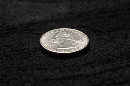 quarter dollar on black concrete dark background .copy spaceの写真素材