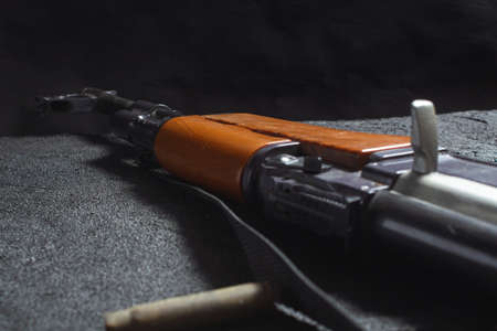 old rusty spent cartridges and a gun barrel on black concrete