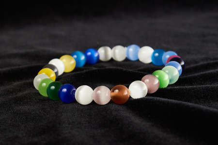 bracelet made of cat's eye semiprecious stone on black velor. close upの写真素材