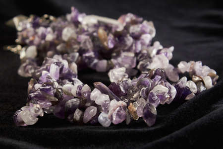 beads from crumbs amethyst semiprecious stone on black velor. close upの写真素材