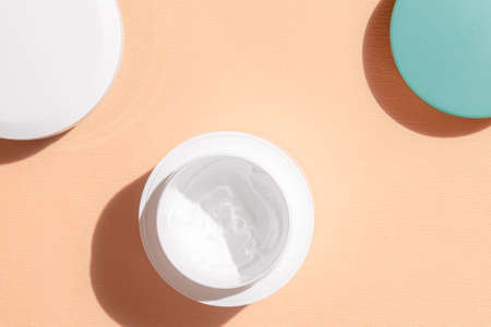 white cream on a peach corrugated background. cream for dry skin. mocap. flat lay