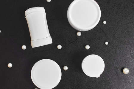 white cosmetic jars for bath pearl deodorant on a black table. Copyspace. mockup. top view. flat layの写真素材