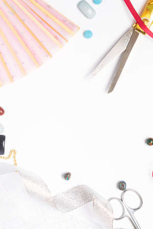 needlework golden scissors ribbons fan natural gems on a light background copy space. top view,...