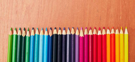 colored pencils in a row according to color temperature on the tableの写真素材
