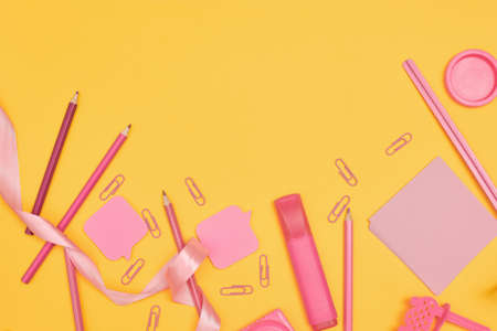 Minimalism, Back to school concept, Pink school supplies on yellow background, flat lay copy space