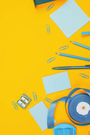 Minimalism, Back to school concept, blue school supplies on yellow background, flat lay copy spaceの写真素材