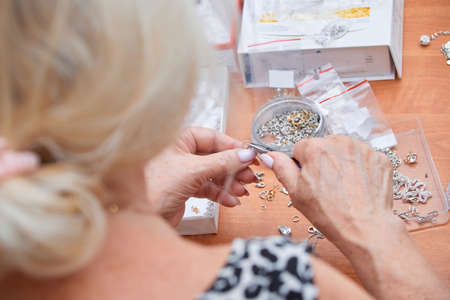 old female hands repairing jewelry, view from the back