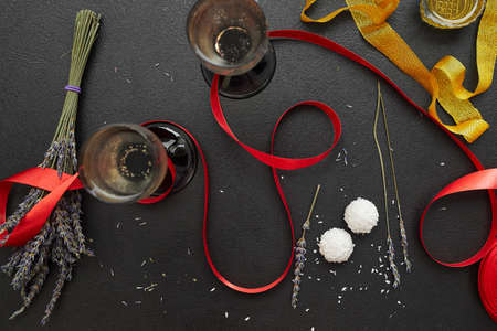 Two glasses of champagne with a red ribbon on a dark background, copy space