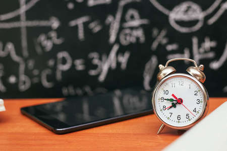 back to school concept, alarm clock on school board background, universityの写真素材