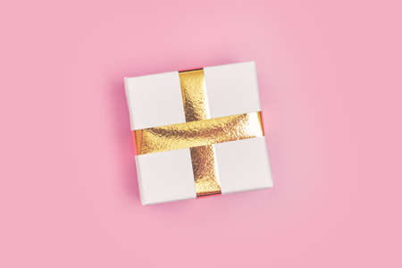New Years gift with gold ribbon on a pink background isolate, copyspace, layoutの写真素材
