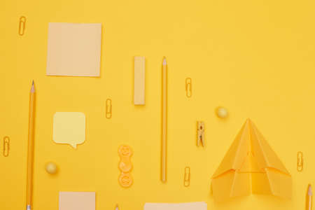 back to school, school supplies lying parallel on yellow background, copy space, top view