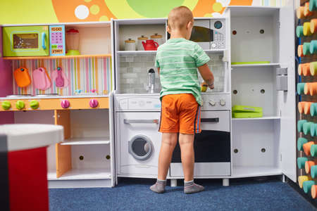 little boy playing in the childrens kitchen oneの写真素材