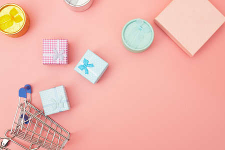 concept black friday, gift boxes with shopping cart on pink pastel background, copy space, flatlay