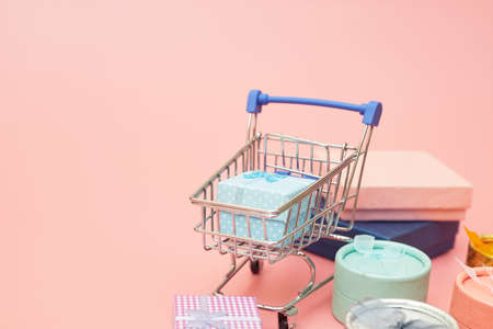 concept black friday, gift boxes with shopping cart on pink pastel background, copy space, flatlayの写真素材